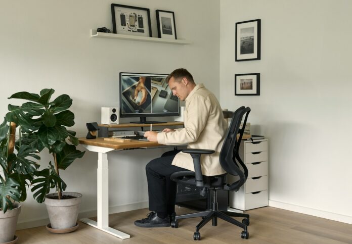 Photo by Lasse Jensen A man sitting at a desk in front of a computer
