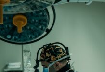 AI 기반 건강 관리, 미래형 의료 혁신의 중심에 서다 a man in a surgical gown is operating a machine