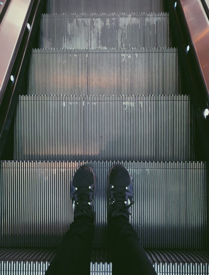 Photo by Rich Smith person standing on escalator