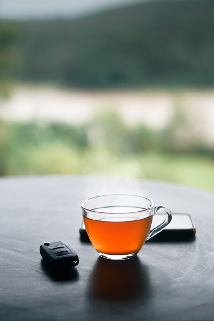 Photo by Manas Manikoth a cup of tea and a cell phone on a table