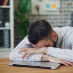 만성피로, 작은 습관으로 극복…나만의 리듬 찾는 실천 팁 주목 a man sitting at a desk with his head in his hands