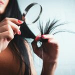 변화하는 헤어 건강 트렌드… 집에서 실천하는 두피 케어 루틴이 인기 Woman examining split ends of hair with magnifying glass