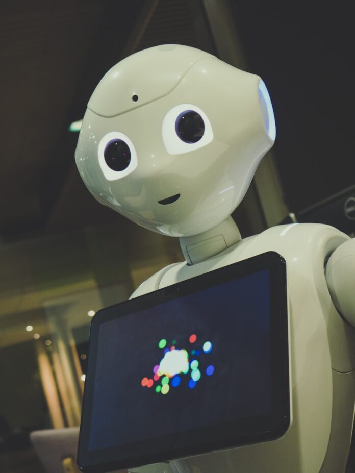 Photo by Owen Beard white robot toy holding black tablet
