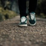 “플렉스 테리오가 대세: 걷기에 재미와 건강 더하는 ‘걷기 명상’ 실천법” a person standing on a gravel road with their shoes on