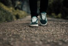 “플렉스 테리오가 대세: 걷기에 재미와 건강 더하는 ‘걷기 명상’ 실천법” a person standing on a gravel road with their shoes on